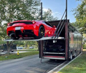 a red car being loaded into a box truck